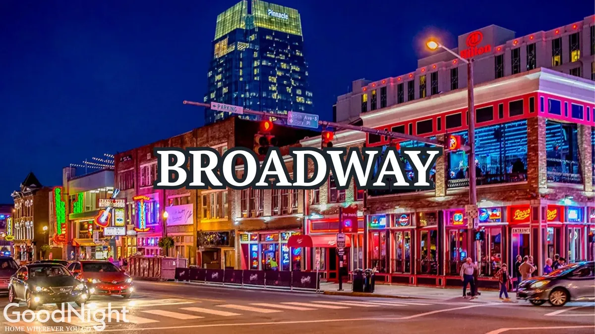 A vibrant nighttime street scene filled with neon signs, bustling crowds, and multiple bars and live music venues. The high-rise buildings towering above and the energetic flow of people capture the essence of Nashville's legendary nightlife on Broadway.